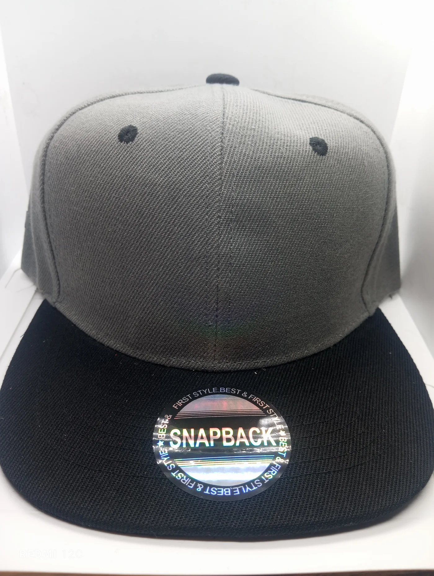 Fotografía real de una gorra gris con visera negra