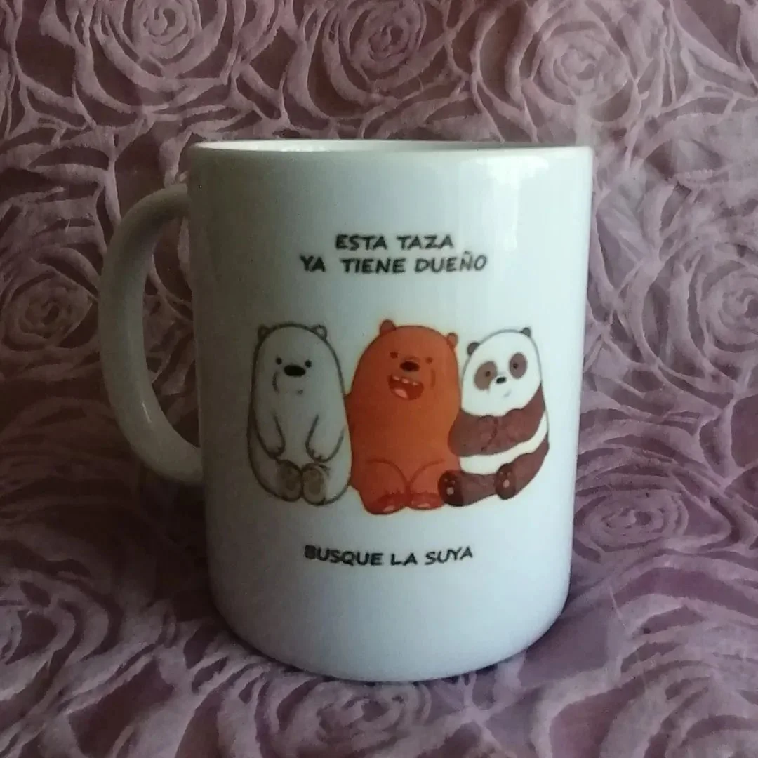 Taza blanca fotografiada con un mensaje y dibujo de osos